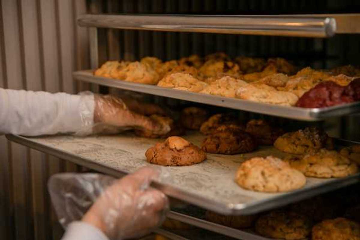 A baker placing baked goods on a tray