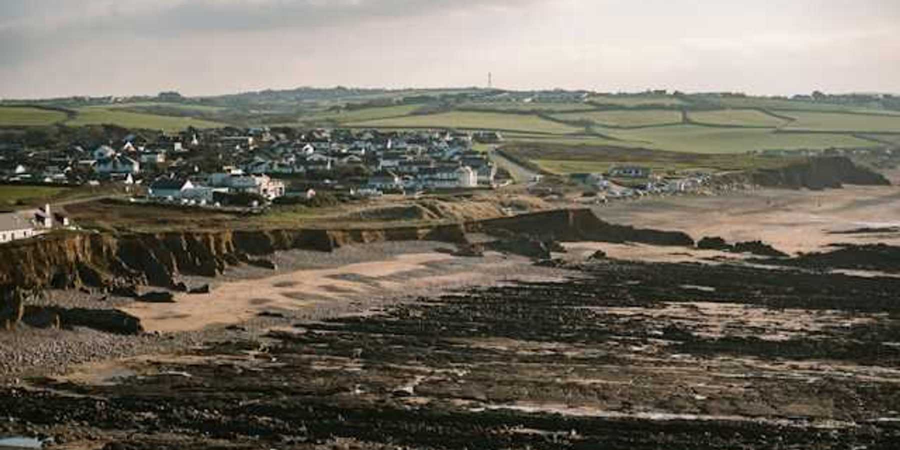 A beach with houses on it and dried up land