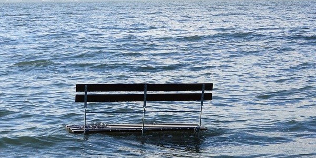 A bench sitting in floodwaters.