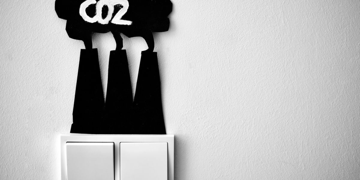 a black and white photo of a light switch with a sign above it indicating Co2 emissions.