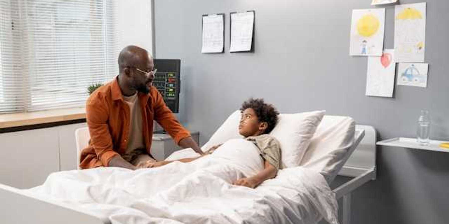 A Black man talking to his child in a hospital bed