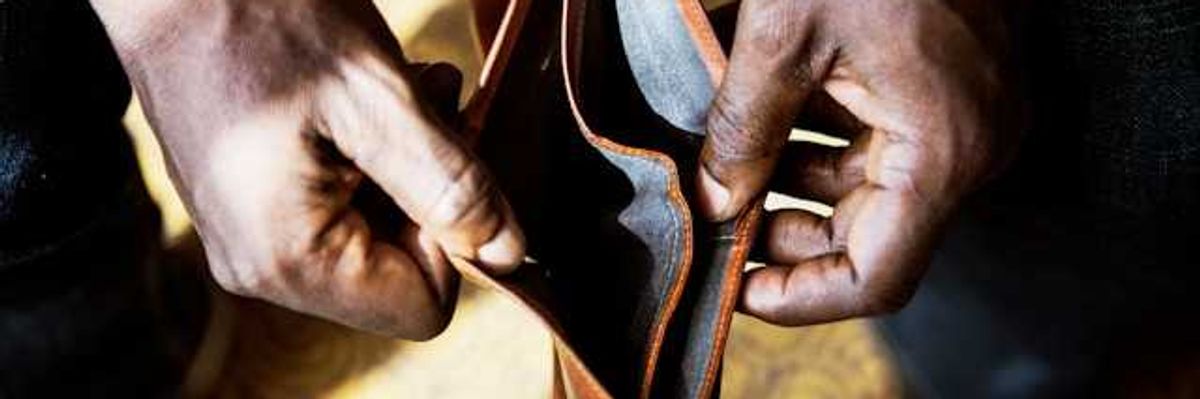 A Black person's hands holding an empty wallet