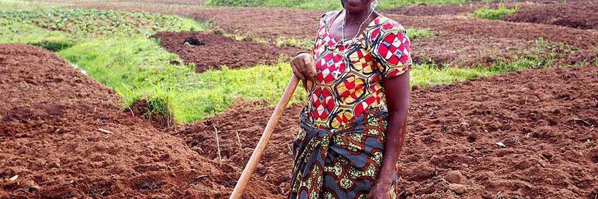 A black woman farmer standing in her fields in Rwanda