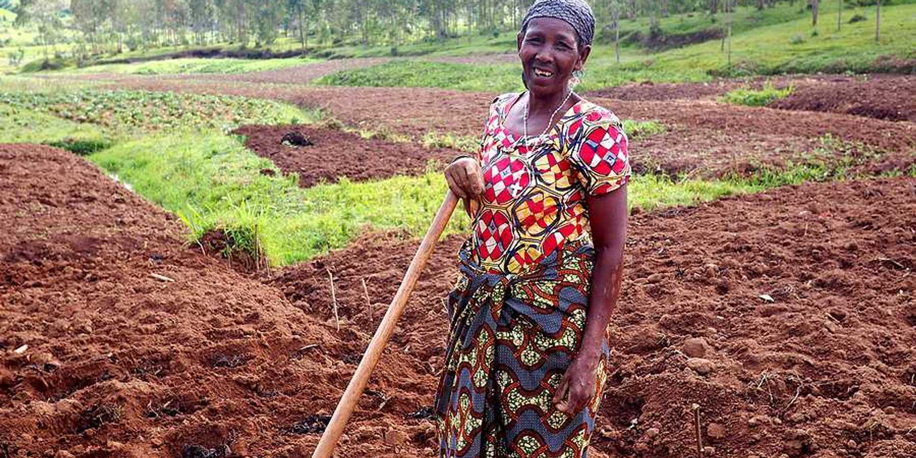 A black woman farmer standing in her fields in Rwanda