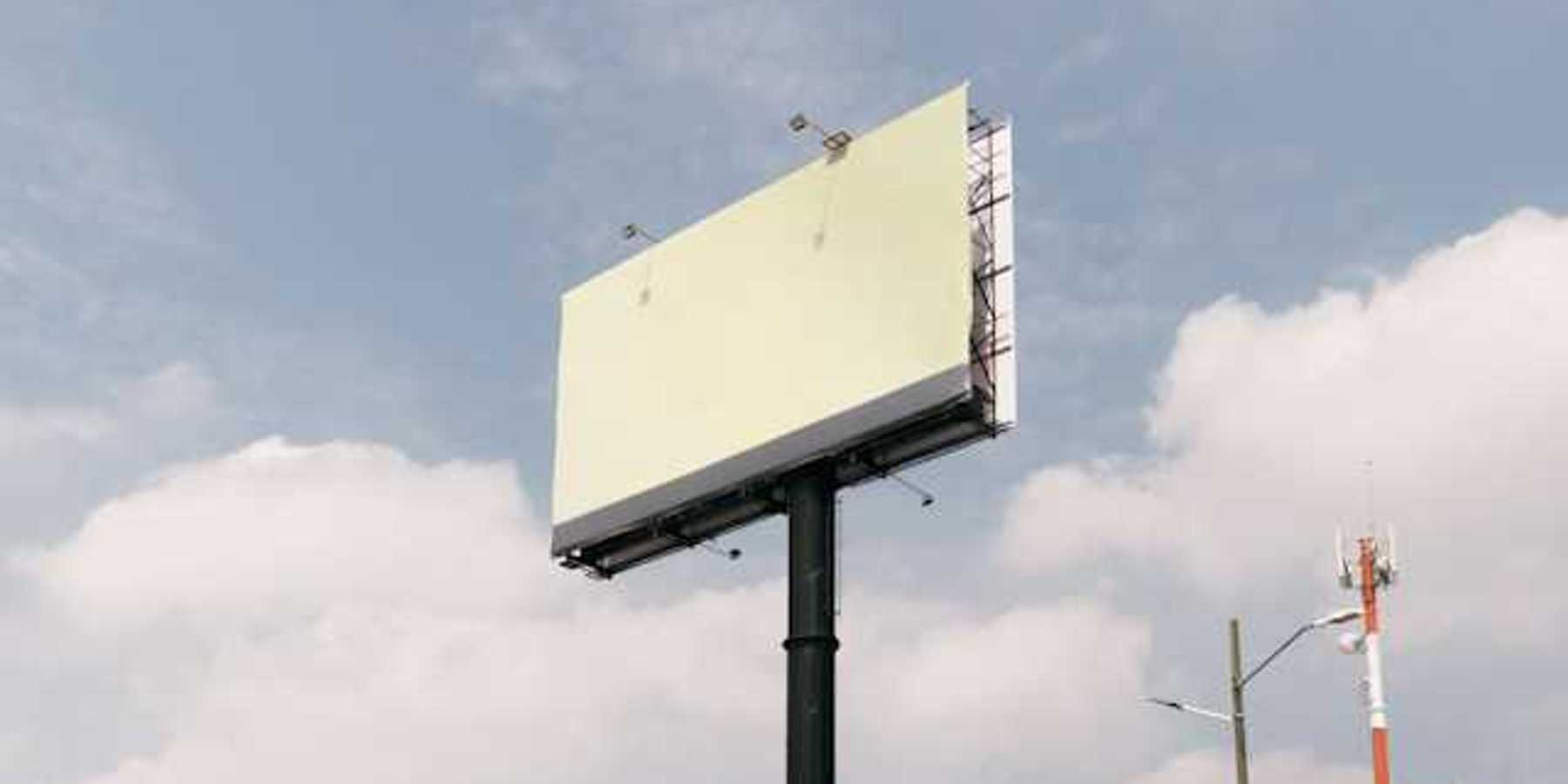 A blank billboard against a blue sky with clouds