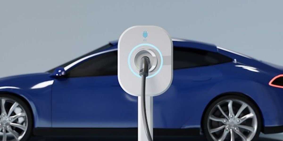 A blue electric vehicle being charged at an EV charging station.