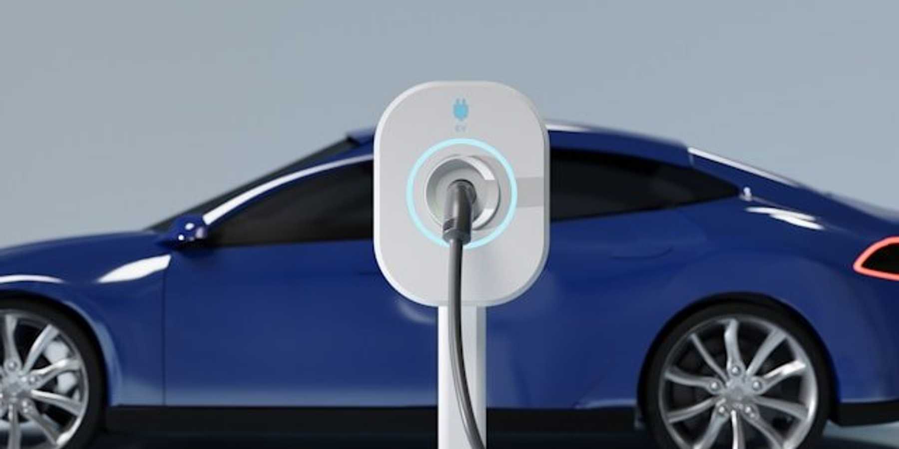 A blue electric vehicle being charged at an EV charging station.