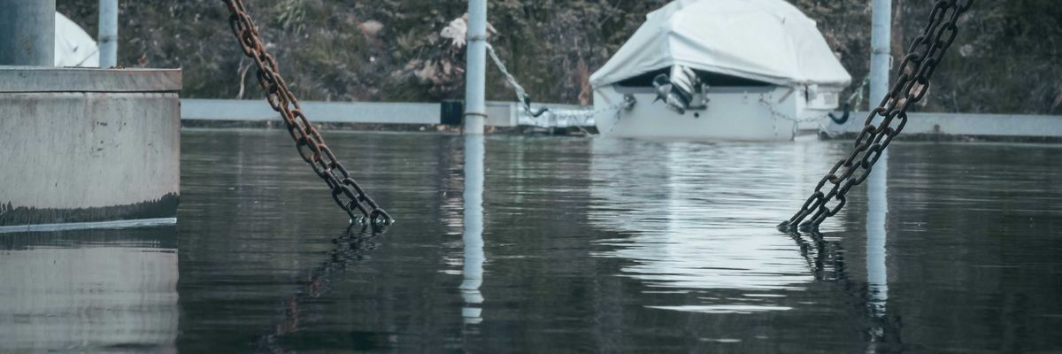 a boat tied to a dock in a flooded area.
