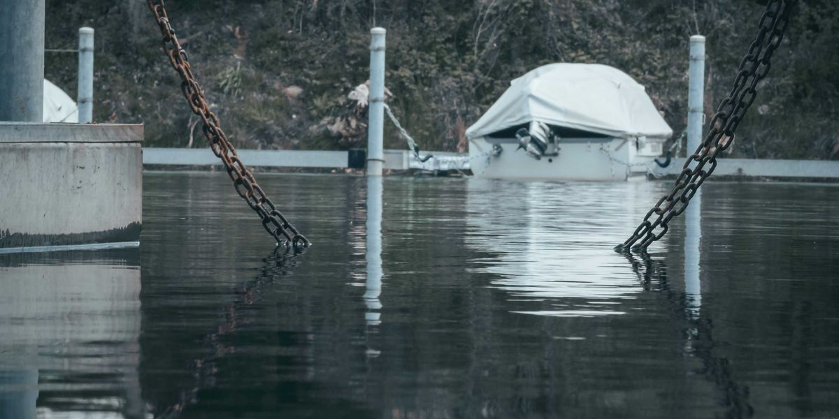 a boat tied to a dock in a flooded area.