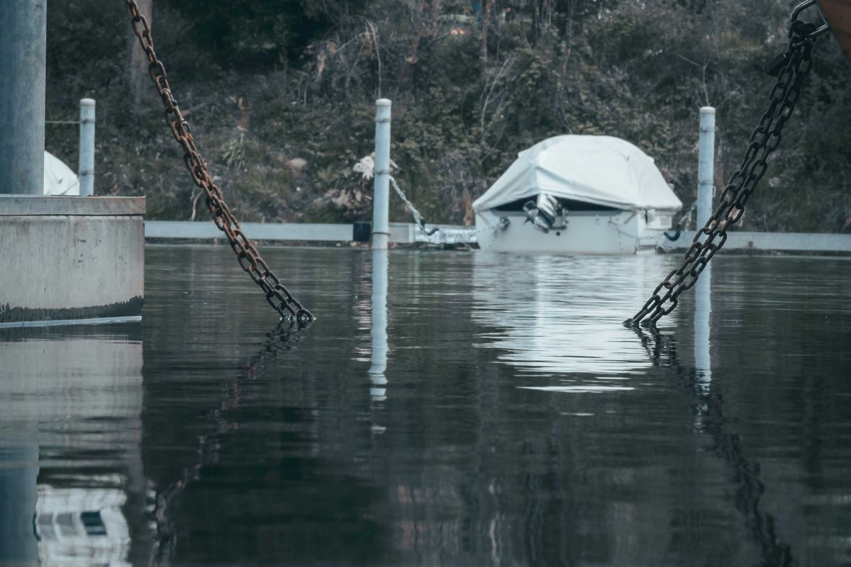a boat tied to a dock in a flooded area.