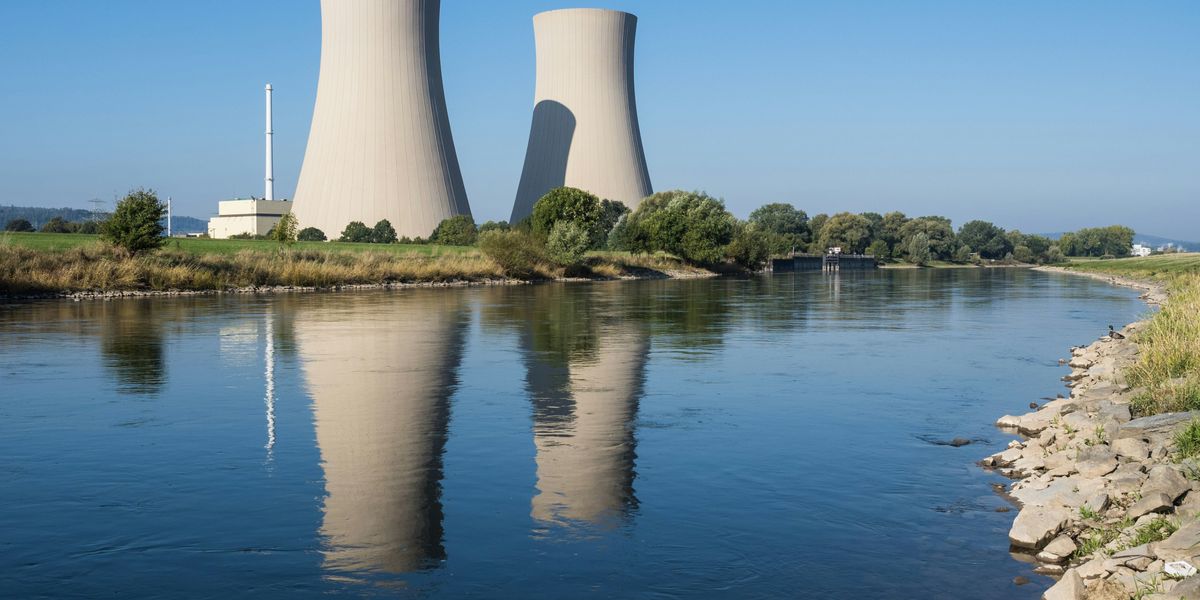 A body of water with two cooling towers in the background.