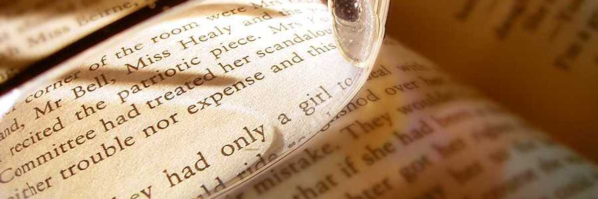 A book with reading glasses magnifying some of the text