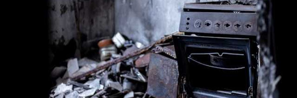 A burned stove in a house that has been destroyed