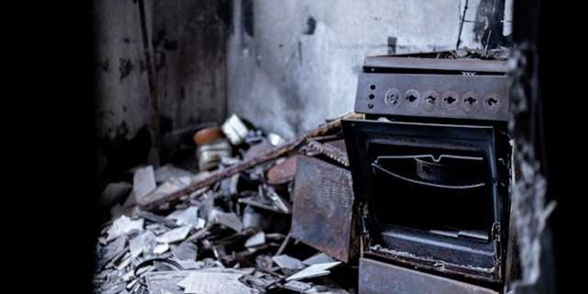 A burned stove in a house that has been destroyed