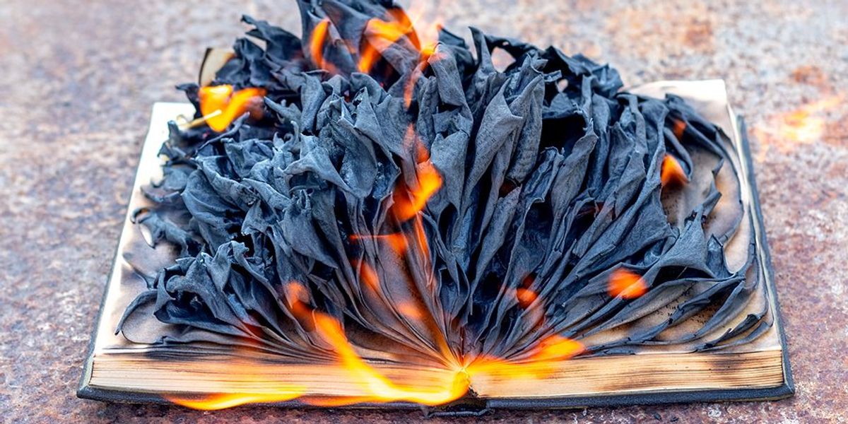 A burning book with flames and blackened, curled pages.