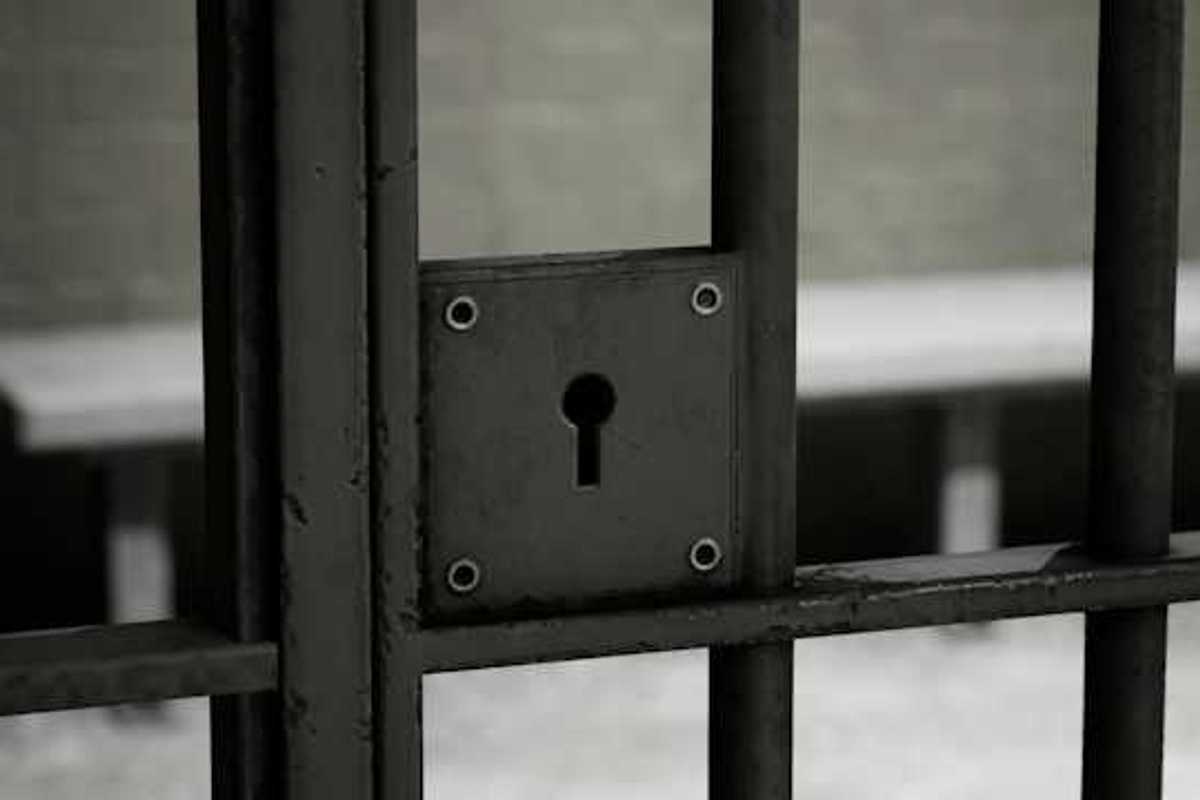 A closeup of a jail cell door with lock