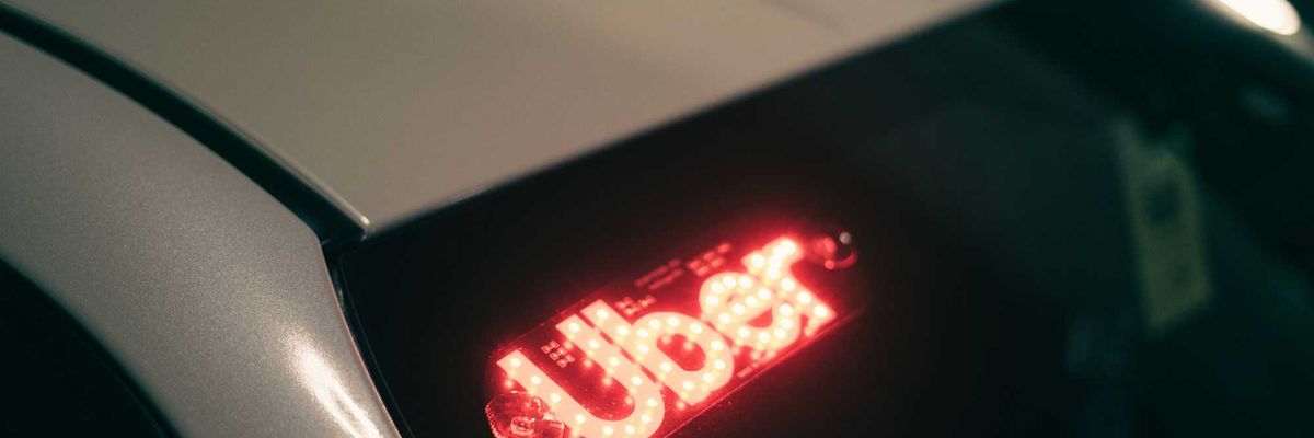 A closeup of an Uber light in the back window of a car