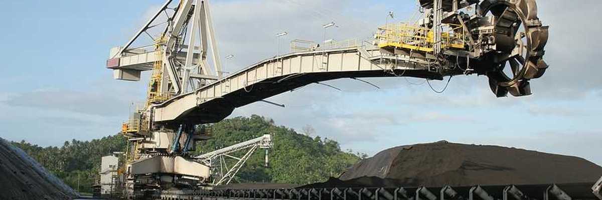 A coal drill hovering over piles of coal