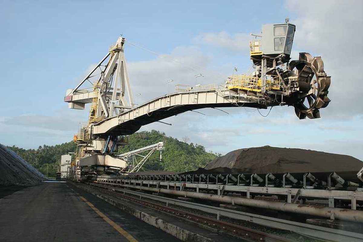 A coal drill hovering over piles of coal