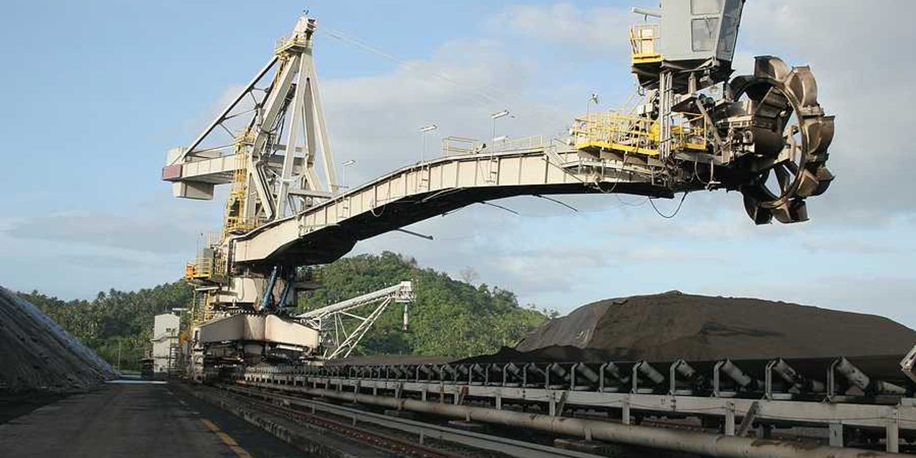 A coal drill hovering over piles of coal