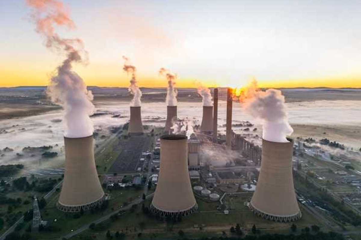 A coal plant viewed from above with smoke emitting from towers