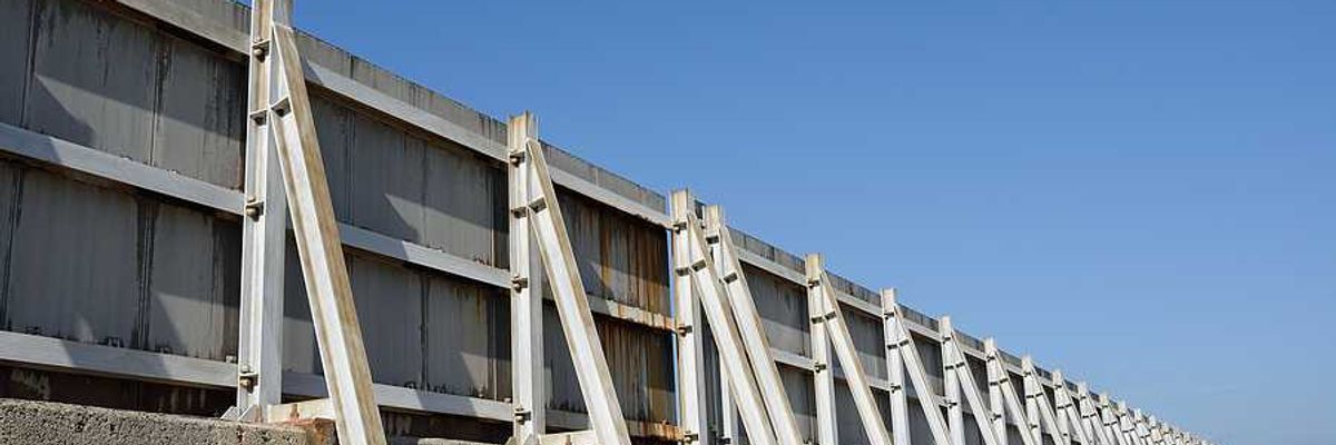 A concrete and metal seawall stretching into the distance