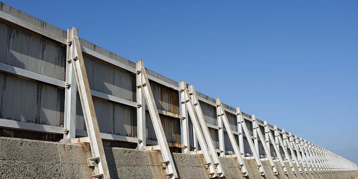 A concrete and metal seawall stretching into the distance