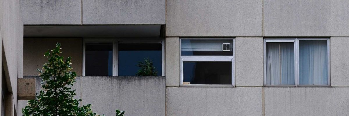 A concrete apartment block with balconies and aluminum windows