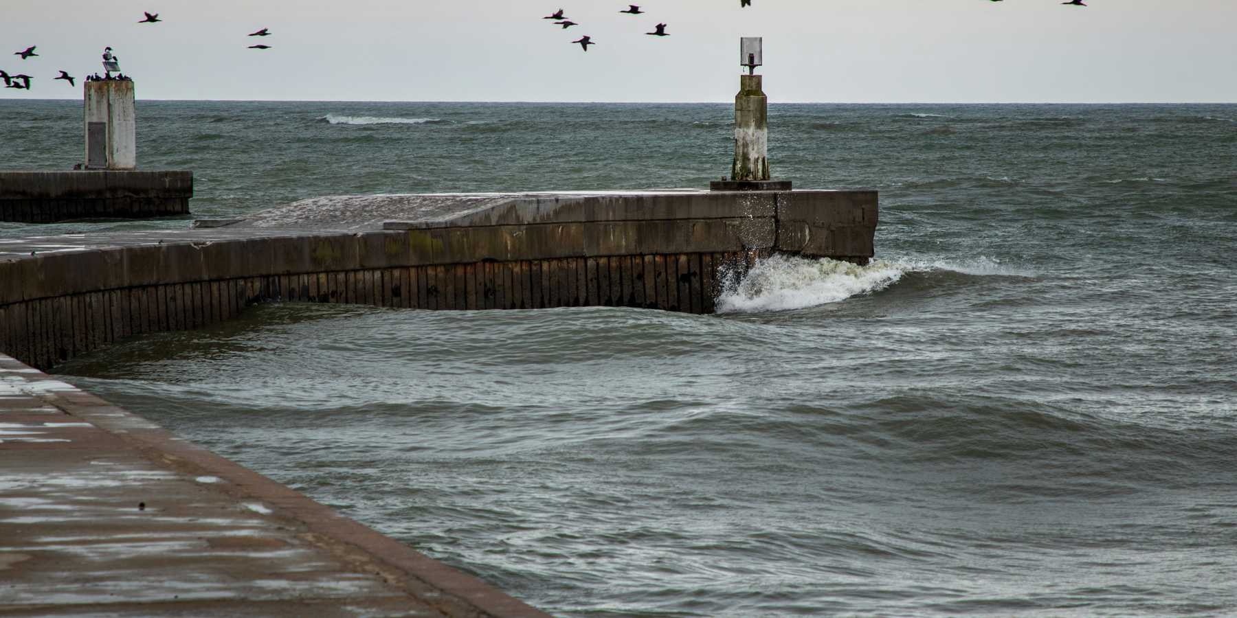 A concrete dock extending into the sea.