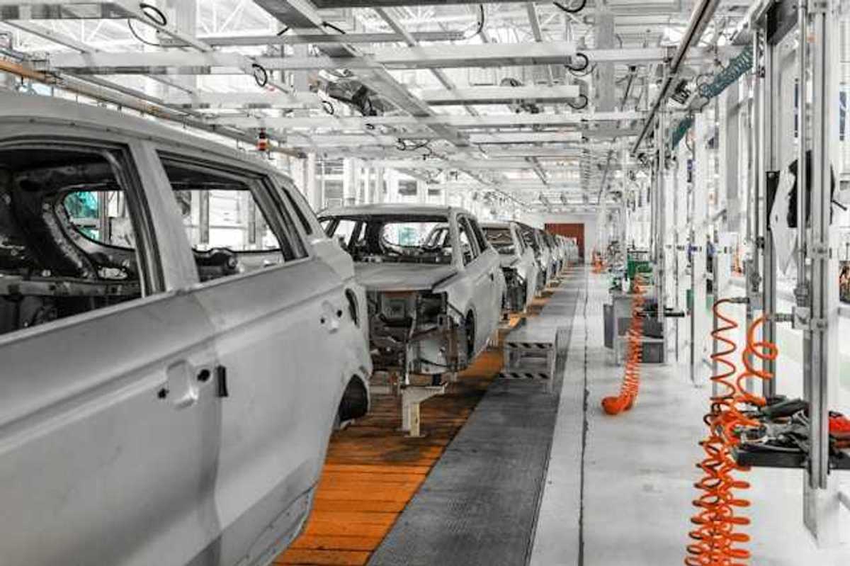 A conveyer belt of electric vehicles being assembled in a factory