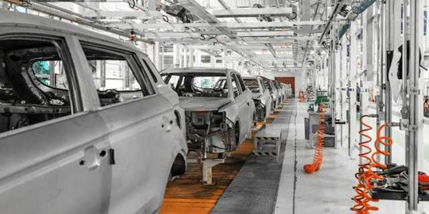 A conveyer belt of electric vehicles being assembled in a factory