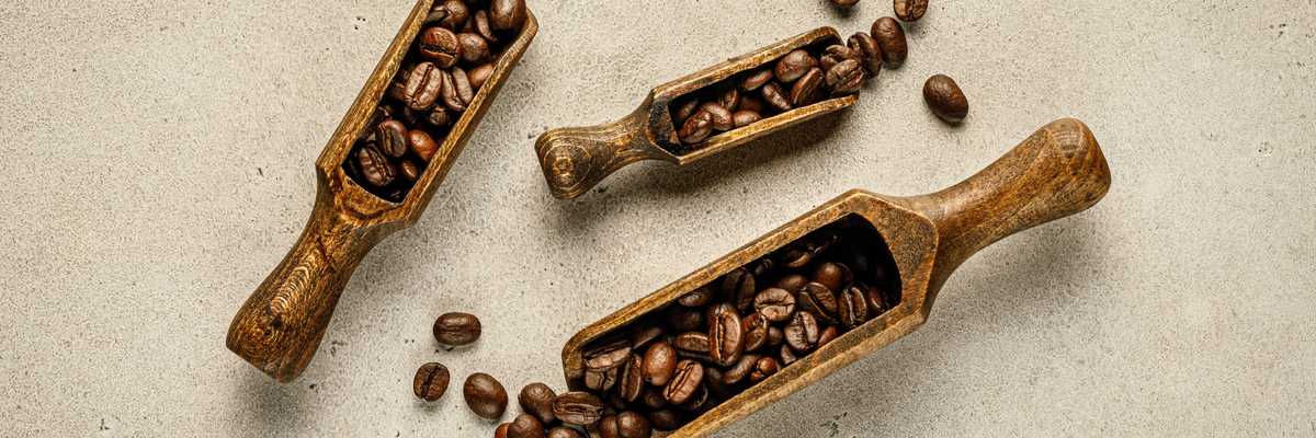 a couple of wooden scoops filled with coffee beans