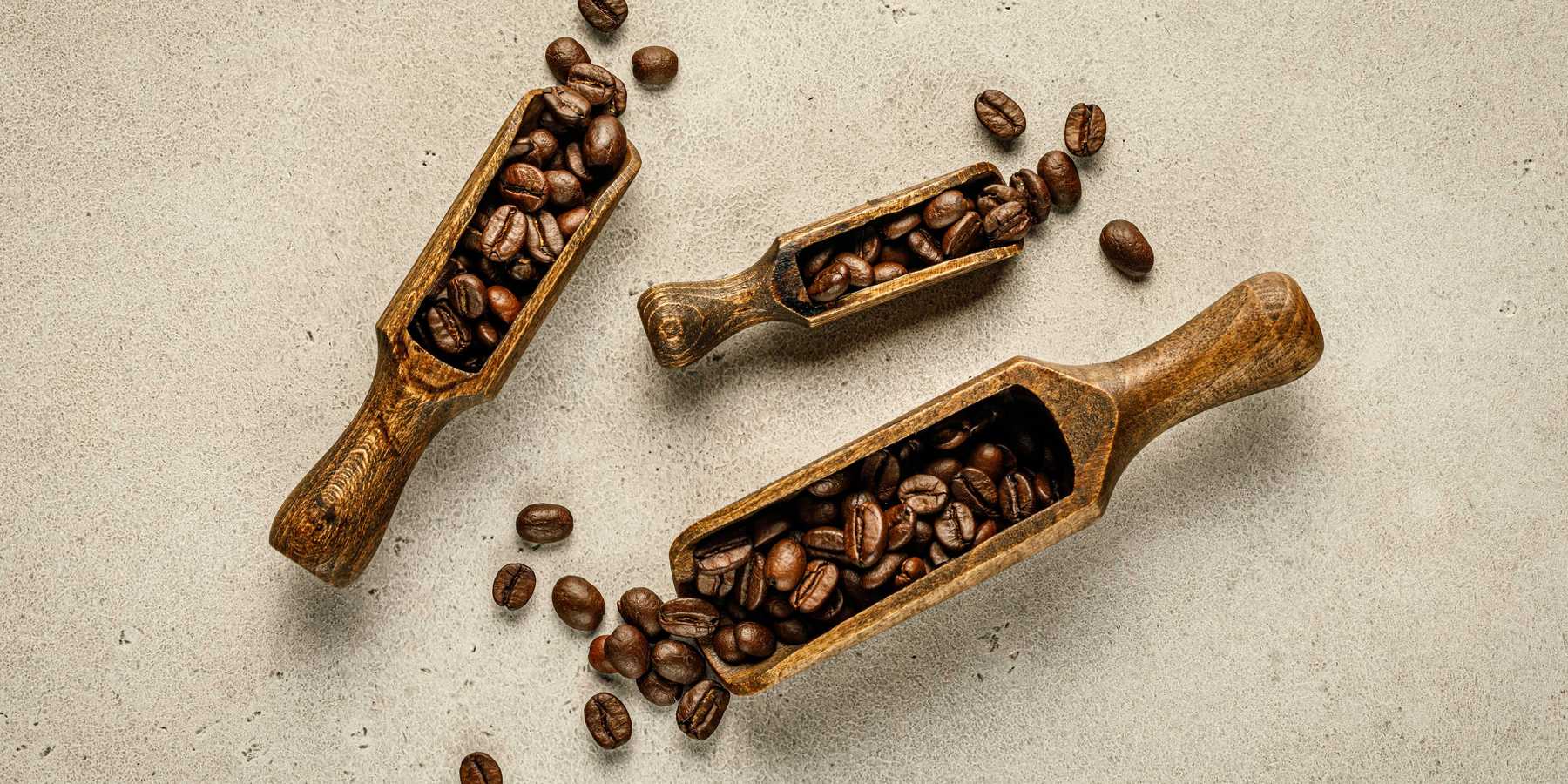 a couple of wooden scoops filled with coffee beans
