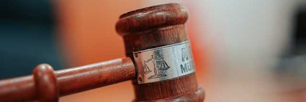 A court room gavel sitting on a wooden surface