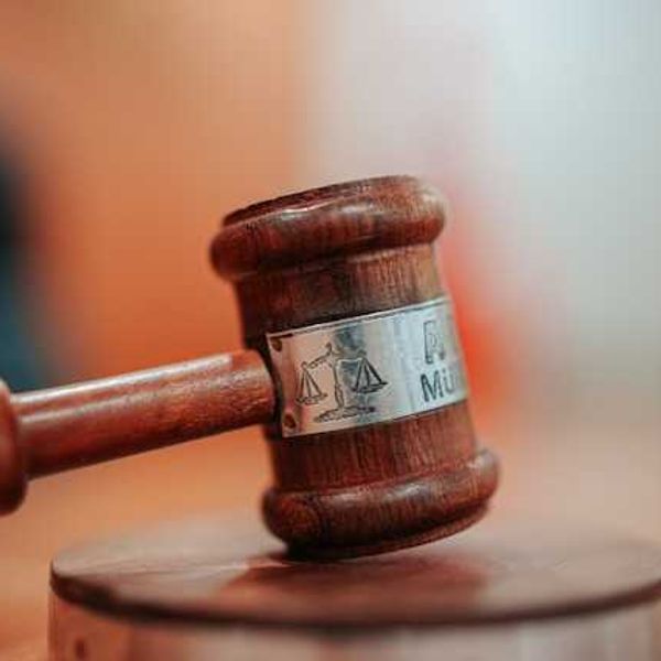 A court room gavel sitting on a wooden surface