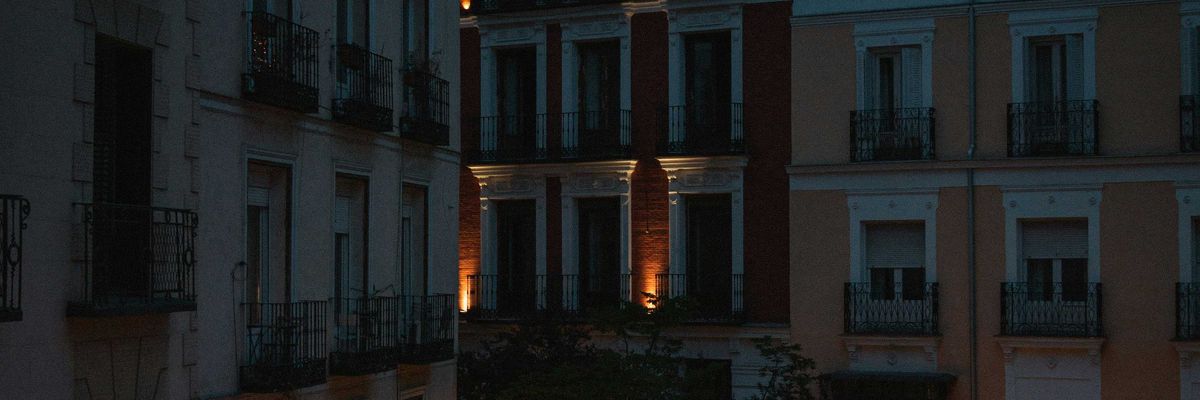 a courtyard with tables and chairs lit up at night.