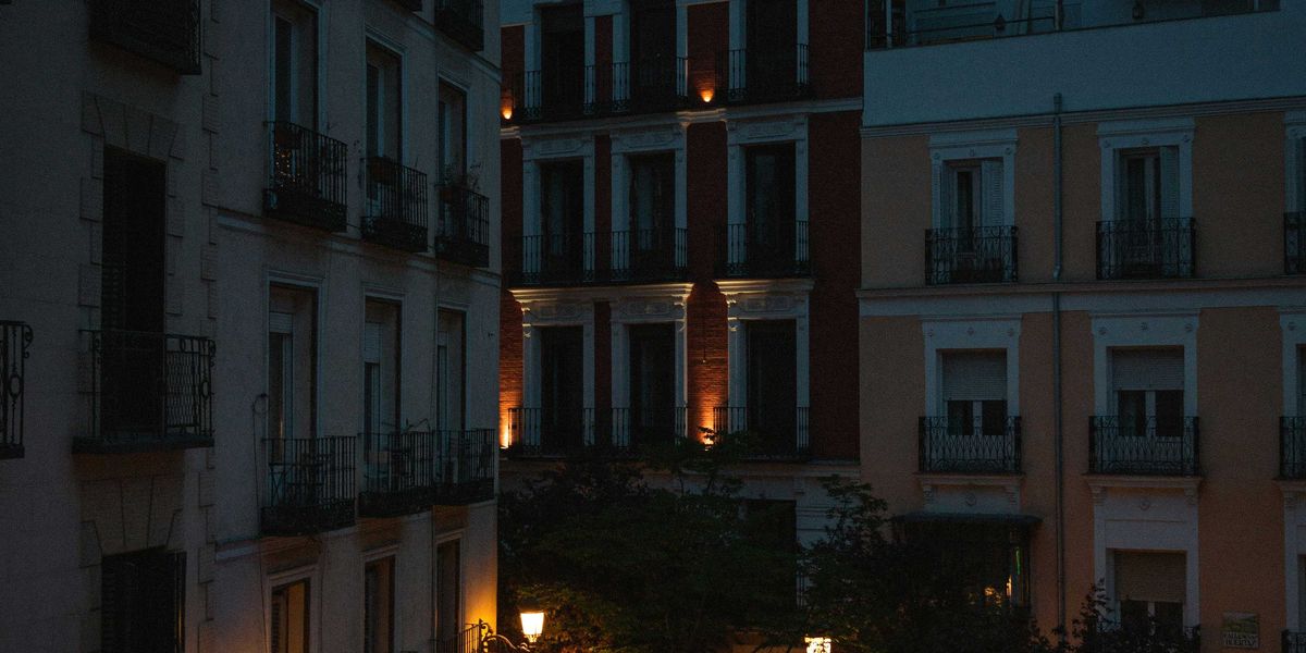 a courtyard with tables and chairs lit up at night.