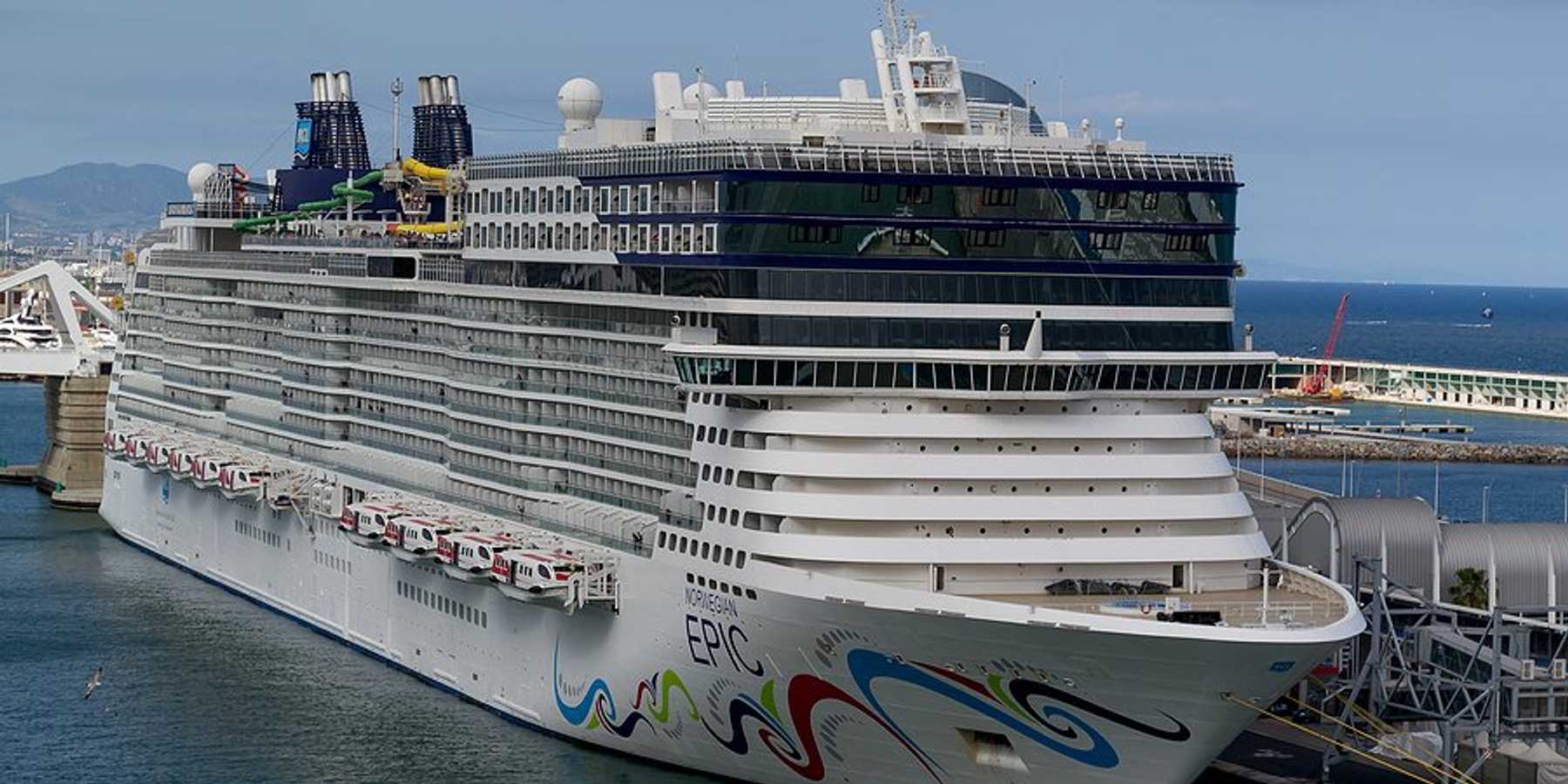 A cruise ship next to a dock in Barcelona Spain.