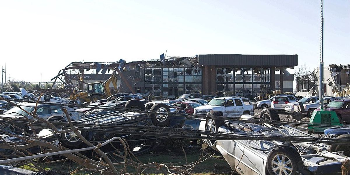 A damaged business with overturned cars.