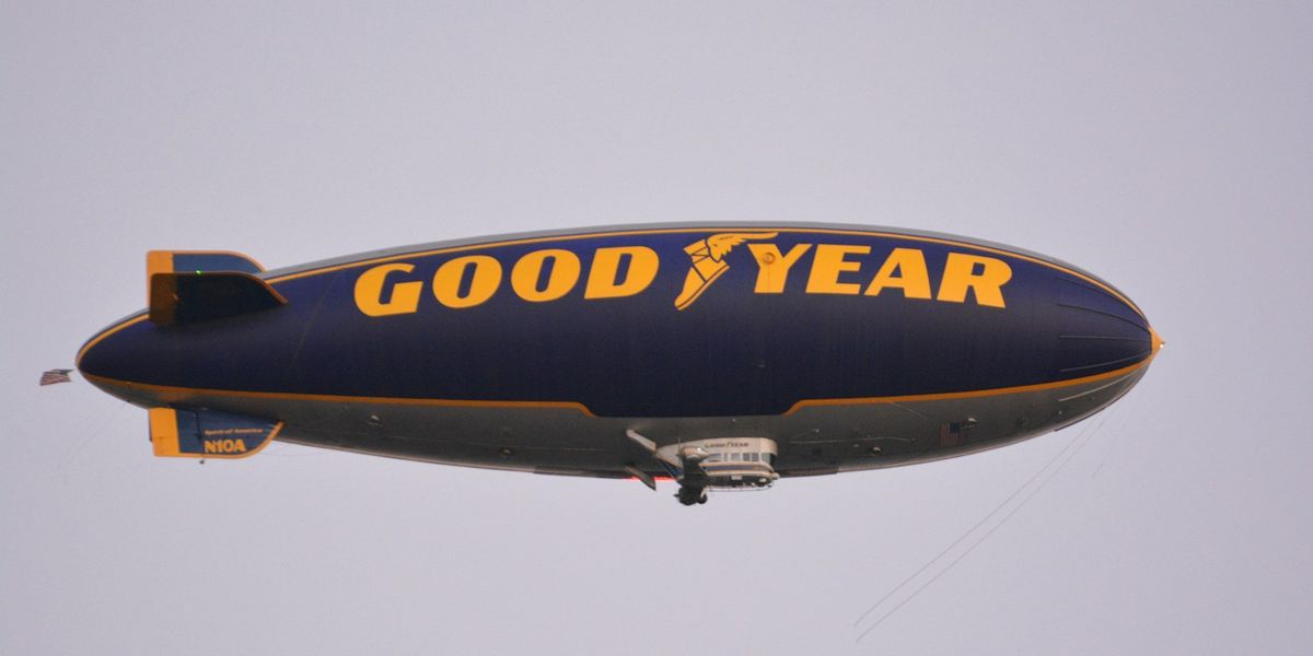 A dark blue blimp or zeppelin with the words "good year" across the side in yellow.