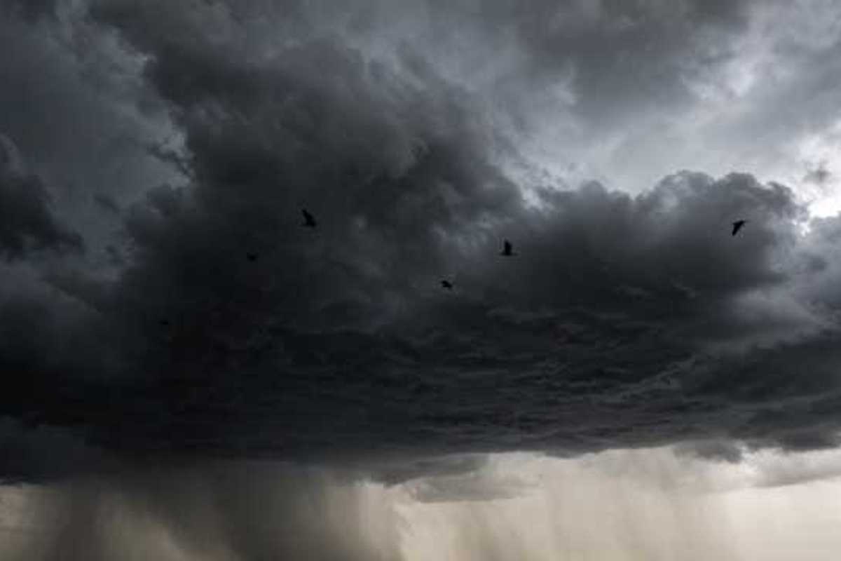 A dark storm cloud with rain in the distance