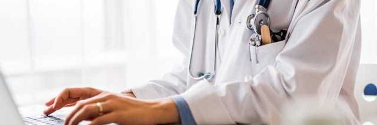 A doctor working on a laptop