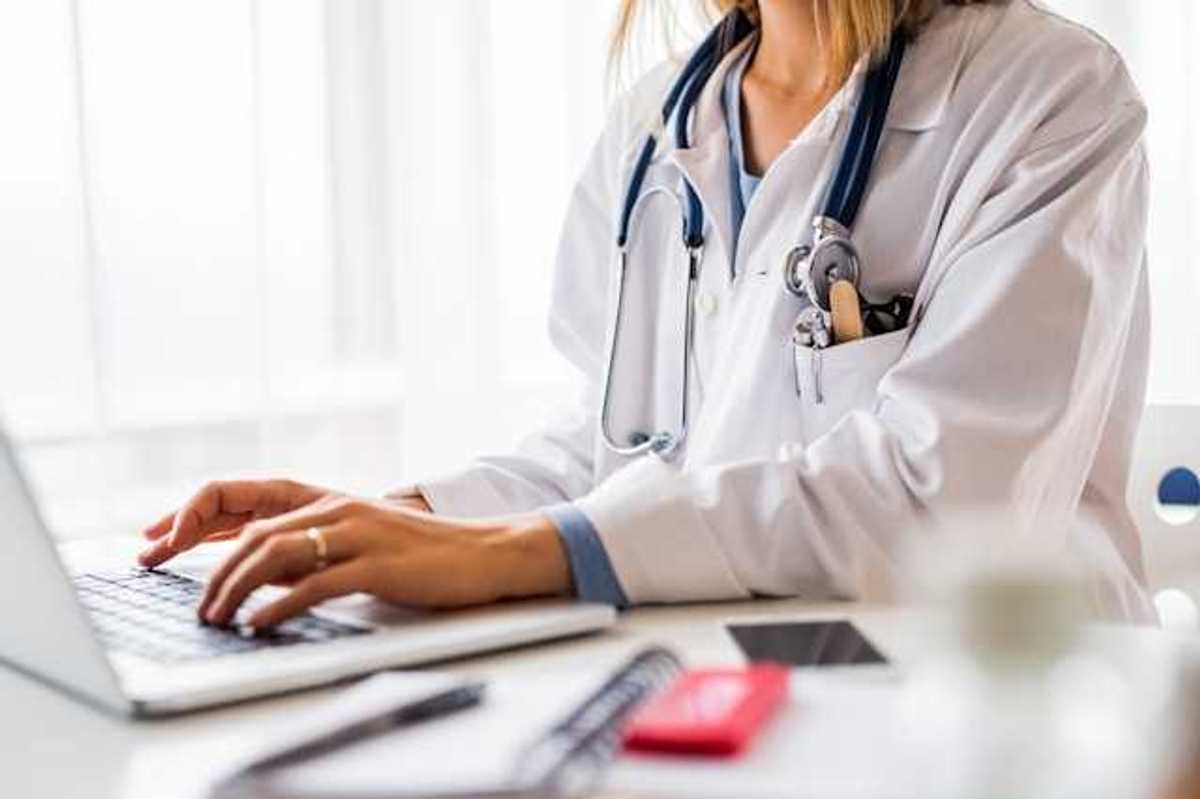 A doctor working on a laptop