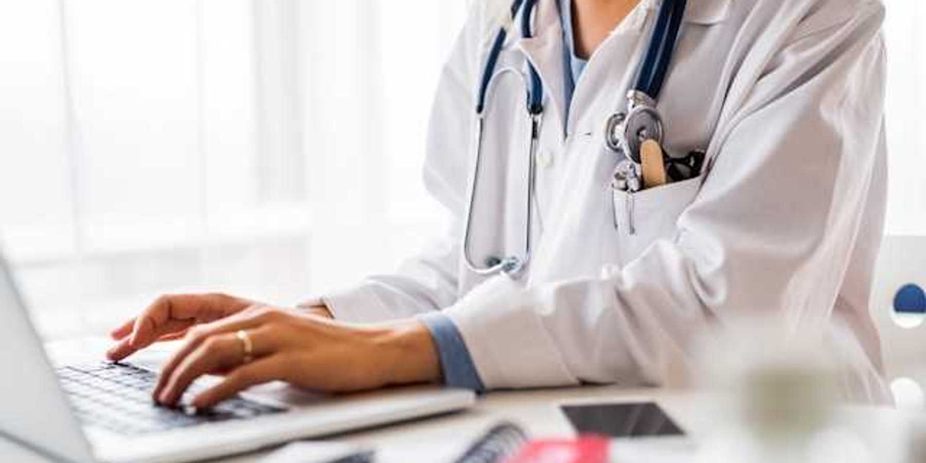 A doctor working on a laptop