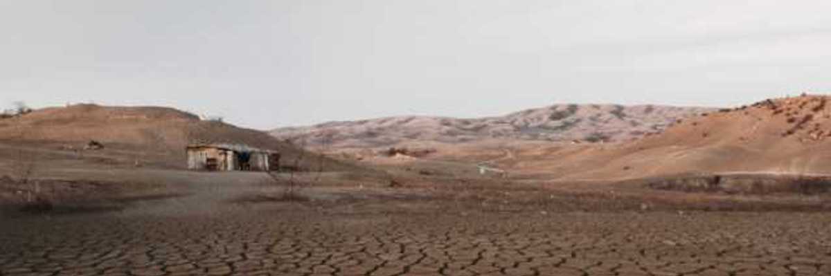 A dried up lakebed with a shack at one end