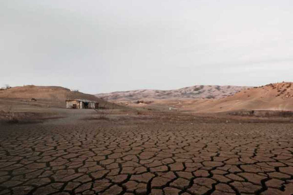 A dried up lakebed with a shack at one end