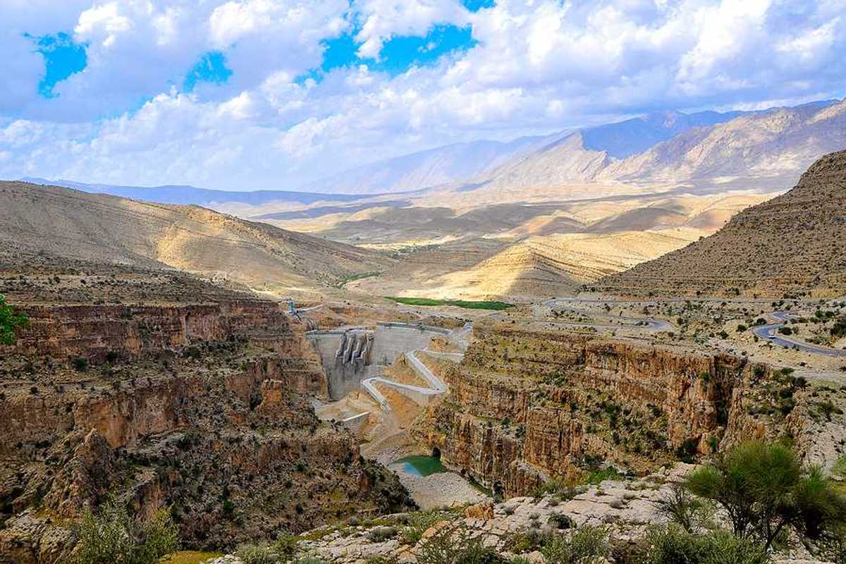 A dry environment with a dam and a small amount of water in view