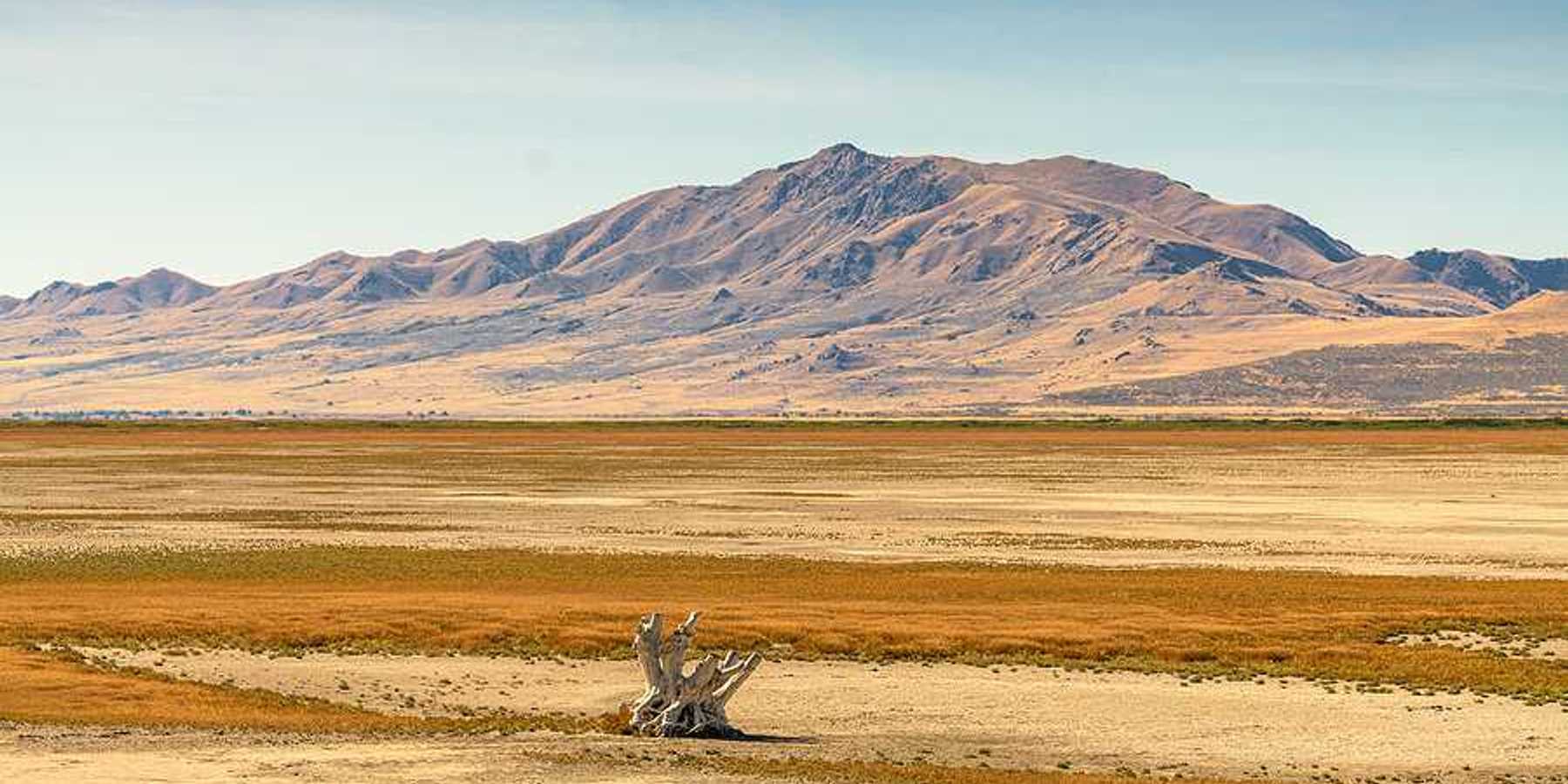 A dry section of the Great Salt Lake with mountains in the background