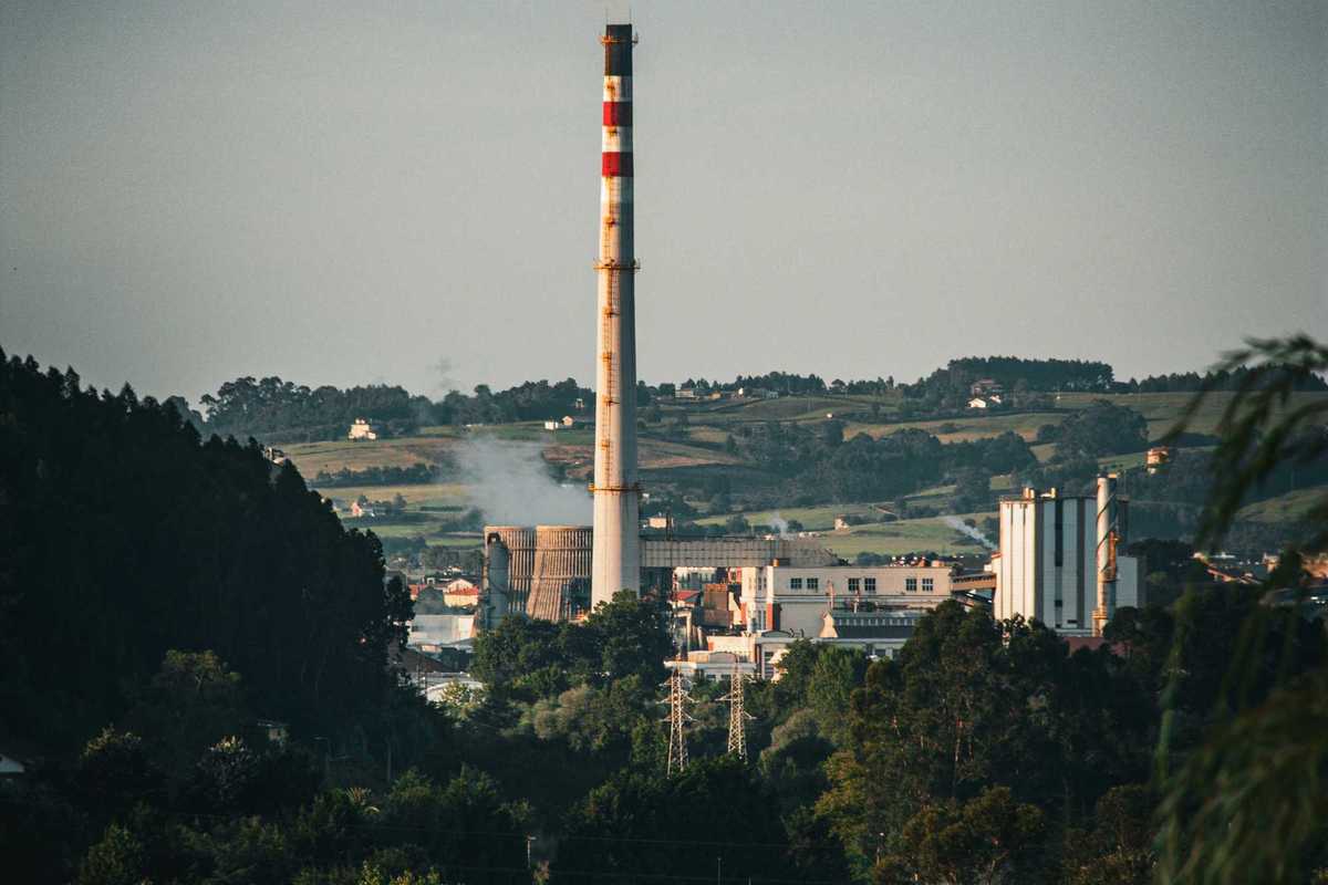 A factory or coal power plant with a smoke stack in the distance.
