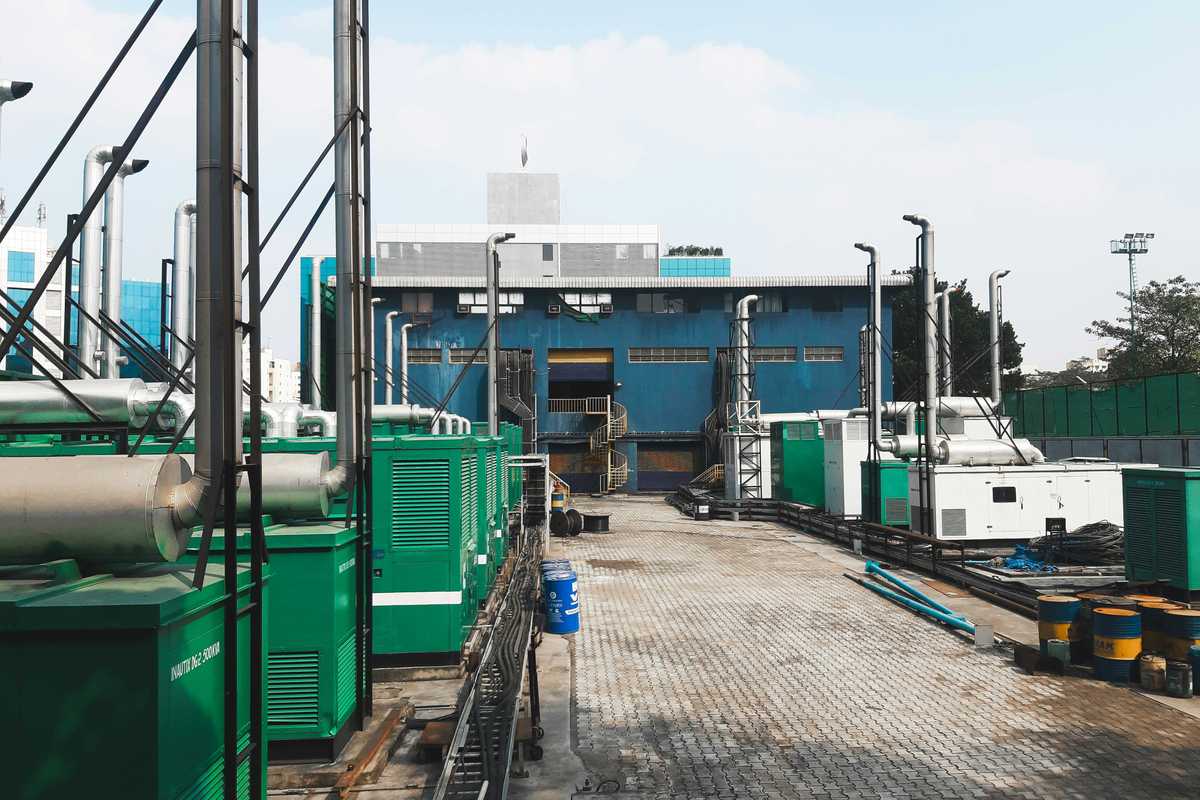 a factory with a lot of green and white generators on platforms outside